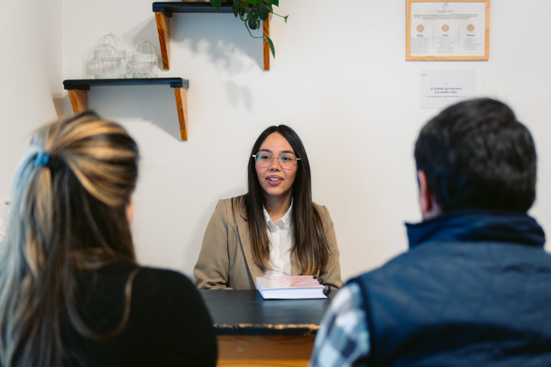 Agustina Orduña, Lic. en Psicología, conversando con dos personas sentadas frente a ella en el consultorio de Centro ANPI.